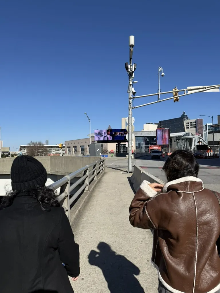 Two people walking with a map beside a traffic signal on an elevated walkway