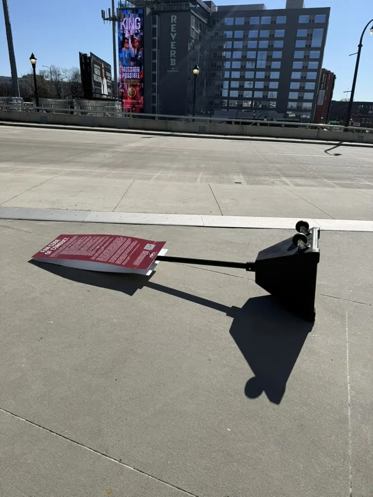 A fallen red sign casting a long shadow across the pavement